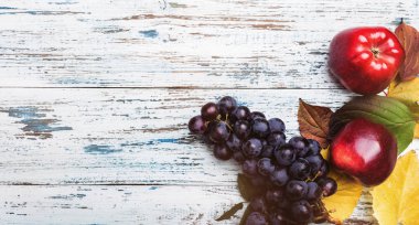 Elma ve üzüm ahşap rustik arka plan üzerinde. Sonbahar meyve, seçici odak üstten görünüm