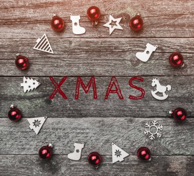 Xmas el yapımı ahşap oyuncaklar ve kırmızı top, bir çember oluşturma. Xmas metin yazma, bir ahşap gri arka plan üzerinde tebrik kartı