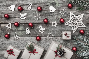 Eski ahşap arka plan üzerinde yatay şeklinin Noel tebrik kartı. Hediyeler ve el yapımı oyuncak. Üstten görünüm.