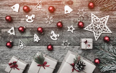 Eski ahşap arka plan üzerinde yatay şeklinin Noel tebrik kartı. Hediyeler ve el yapımı oyuncak. Metin için yer. Üstten görünüm. Işık etkisi