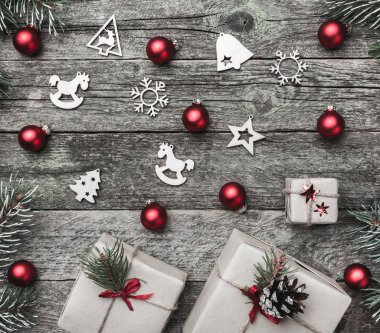 Eski ahşap arka plan üzerinde kare şeklinin Noel kartı. Hediyeler ve el yapımı oyuncak. Üstten görünüm.