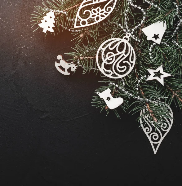 Noel tebrik kartı yeşil çam ağacı Ahşap oyuncaklar ile siyah taş zemin üzerine. Üstten görünüm. Senin metin için yer ile. Kar etkisi