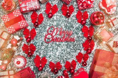 Kırmızı yay ve ağaç topları Merry Christmas ve el yapımı Dekorotif oyuncakları, mevcut kutuları, mermer arka plan, Noel tebrik kartı ile daire. Allık etkisi
