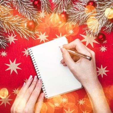 Noel kartı, eller Miss, Noel Baba'ya bir mektup yazar. Çam dalları Noel topları ile. Üstten görünüm.