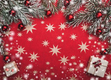 Noel kartı, kırmızı arka plan ile yıldız. Senin metin için yer. Köknar kırmızı topları ile dalları. Üstten görünüm. Kar etkisi