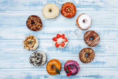 Eski ahşap zemin üzerine çeşitli Donuts bir daire. Üstten görünüm.