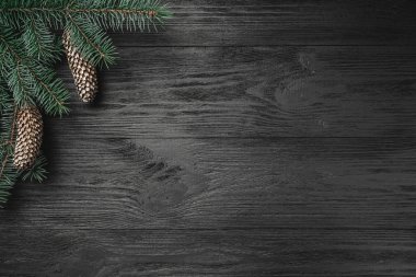 Noel kartı. Siyah ahşap zemin, ocreanga ve çam kozalakları köşede, üstten görünüm