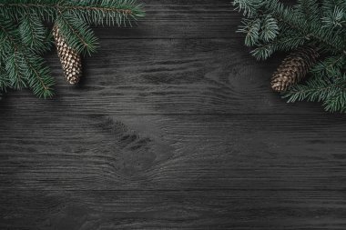 Noel kartı. Üst köşelerinde ocreanga ve köknar koniler ile ahşap arka plan siyah, görünümü ana sayfa