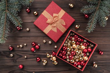 Hediye kutuları kahverengi ahşap zemin üzerinde toplar. Köknar ağacı baubles, metin için yer. Üstten görünüm.