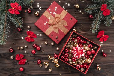 Hediye kutuları topları ve diğer tatil öğelerle kahverengi ahşap zemin üzerinde. Köknar ağacı baubles, metin için yer. Üstten görünüm.