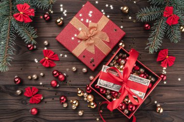 Hediye kutuları topları ve diğer tatil öğelerle kahverengi ahşap zemin üzerinde. Köknar ağacı baubles, metin için yer. Üstten görünüm.