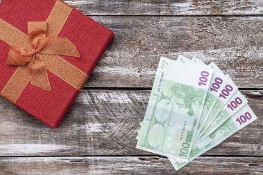 Bir Noel hediyesi, para, Xmas öğeleri, ahşap arka plan üzerinde. Üstten görünüm.