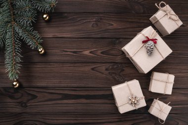 Koyu ahşap arka plan üzerinde hediye kutuları. Üstten görünüm. Çam ağacıyla baubles, metin için yer.