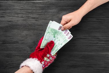 Siyah ahşap arka plan. Noel Baba'nın hediye. Noel kartı. Üstten görünüm. Xmas tebrikler. Baba para verir.