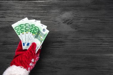 Siyah ahşap arka plan. Noel Baba'nın hediye. Noel kartı. Üstten görünüm. Xmas tebrikler. Baba para verir.
