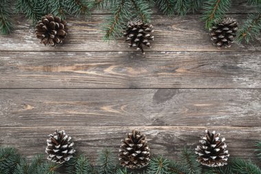 Koniler ile süslü çam dalları ile eski ahşap arka plan. Metin için yer. Noel kartı. Üstten görünüm. Xmas.