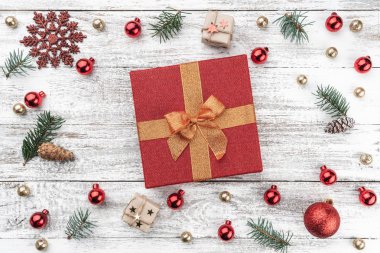 Eski arka plan ağaç christmas karede. Kırmızı ve altın Baubles. Çam dalları ve koniler. Ortadaki kırmızı bir hediye. Xmas öğeleri. Üstten görünüm.