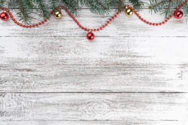 Eski ahşap Noel arka plan. Çam dalları. Altın ve kırmızı baubles. Kırmızı çelenk. Noel kartı. Üstten görünüm. Senin metin için yer.