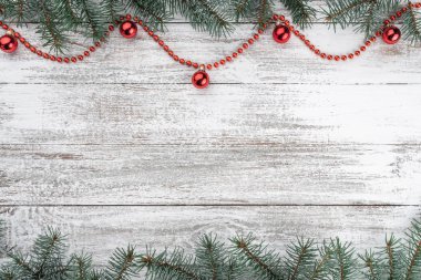 Noel kartı. Eski ahşap Noel arka plan. Çam dalları. Kırmızı baubles ve çelenk. Üstten görünüm. Senin metin için yer.