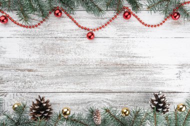 Eski ahşap Noel arka plan. Çam dalları ve koniler. Altın ve kırmızı baubles ve çelenk. Üstten görünüm. Senin metin için yer. Noel kartı.