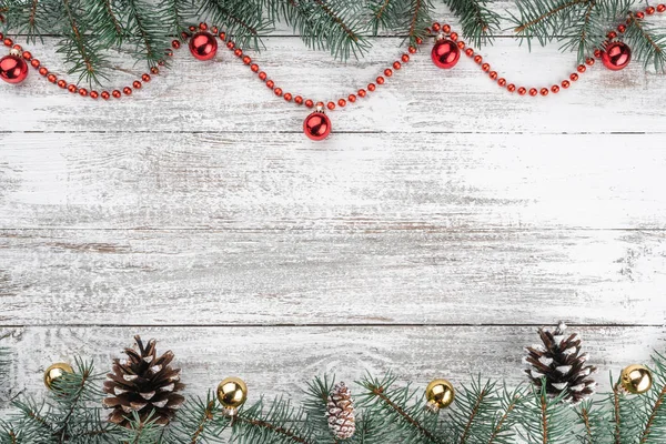 Eski ahşap Noel arka plan. Çam dalları ve koniler. Altın ve kırmızı baubles ve çelenk. Üstten görünüm. Senin metin için yer. Noel kartı.