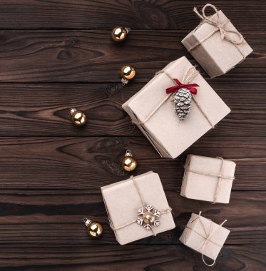 Koyu ahşap arka plan üzerinde hediye kutuları. Köknar ağacı baubles, metin için yer. Üstten görünüm. Xmas kare kartı.