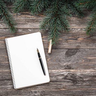 Çam dalları ile eski ahşap arka plan. Not defteri. Noel kartı. Üstten görünüm. Xmas kare kartı.