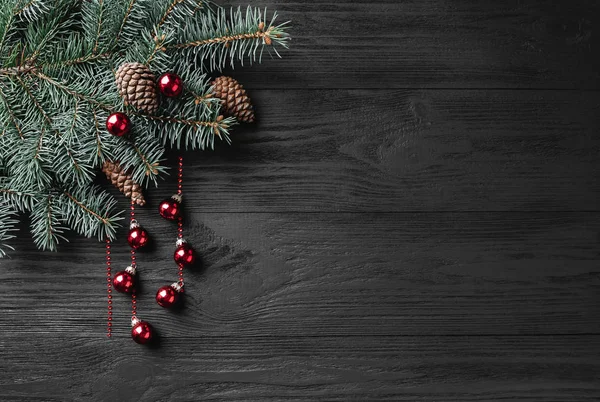 Fundo de Natal de férias com ramo de abeto em uma mesa de madeira escura. Natal e feliz ano novo cartão de saudação. Espaço para cópia. Vista de cima. Localização plana, local para texto . — Fotografia de Stock