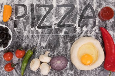 Taştaki tabloda un üzerinde Pizza yazıt yayıldı. Taze malzemelerle pizza yemek için. Gıda arka plan. Gıda kavramı. Üstten görünüm. Metin için yer