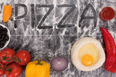 Taştaki tabloda un üzerinde Pizza yazıt yayıldı. Taze malzemelerle pizza yemek için. Gıda arka plan. Gıda kavramı. Üstten görünüm. Metin için yer