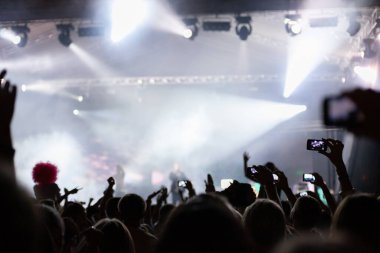 Geceleri konserde cep telefonuyla çekim yapan bir sürü insan var.