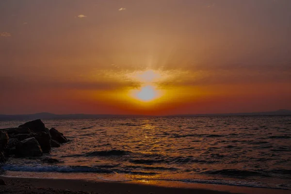 Sunset or sunrise, on the coast of the sea or the ocean, in the distance you can see mountains