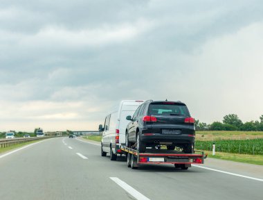 Karayolu üzerinde yeni araç ile araba taşıyıcı römork