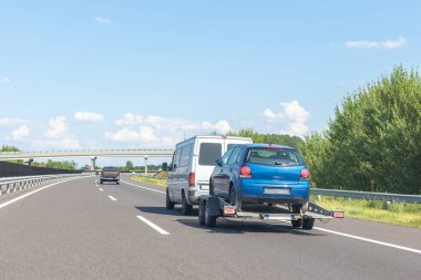 Otoyolda mavi arabası olan bir karavan..