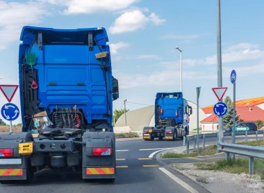 İki yeni mavi kamyon taksisi. Büyük güçlü traktörler kavşağa gider.