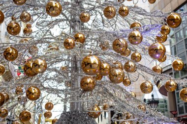 Alışılmadık yapay Noel ağacı şehrin merkezinde sarı toplarla süslenmiş ampullerle örülmüş metal dallardan yapılmıştır.