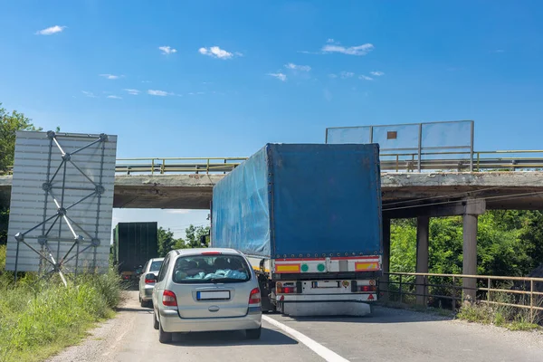 Mavi hat yükseltilmiş yolun altından geçmeye çalışıyor. Kamyon köprüye çarpıyor.