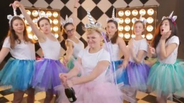 Renkli etekli güzel kızlar gülüyor, sıcak sınır ışıklarında şampanya patlatıyorlar. Neşeli manken eğleniyor, gününü kutluyor.