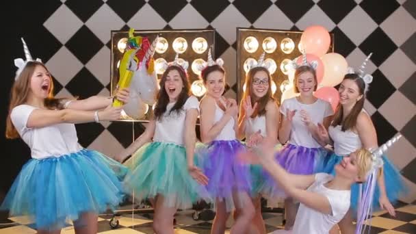 Szczęśliwy przyjaciel imprezowanie dziewczyny są próbuje wysadzić a krakers z confetti — Wideo stockowe