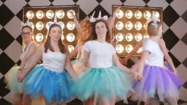 neşeli bir grup genç kızların tavuk parti - parlak nokta stüdyo ışık ekipmanları arka planı stüdyosunda şenlikli videoda kutlayan gelin, etrafta dans ediyor