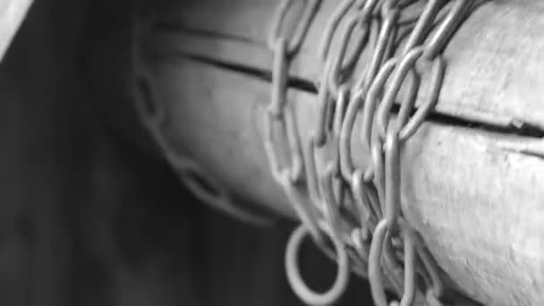 Iron chain of an old village well rotates on a wooden jamb — Stock Video