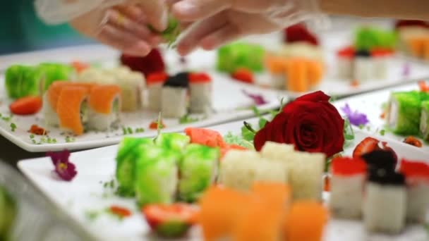 Adornar con flores surtido delicadeza sushi en platos blancos — Vídeo de stock