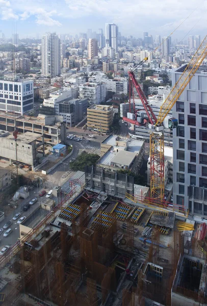Modern city. Office building top view. Crane and building construction site against blue sky. Isreal, Ramat-gan.
