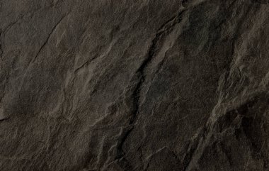 Kabataslak yüzeyi ve çatlakları olan doğal koyu taş dokusu, arka plan veya tasarım elementleri için idealdir..