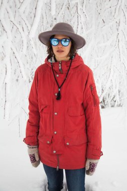 Kırmızı ceketli kızın kış yürüyüşü var.