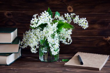 Demet çiçekler kuş kiraz ve bir kitap yığını