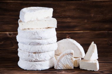 Bütün camembert peyniri rustik kahverengi ahşap zemin üzerinde