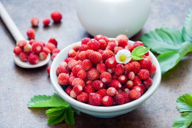 Yaban çilekleri ve kahverengi bir arka plan üzerinde süt ile kahvaltı