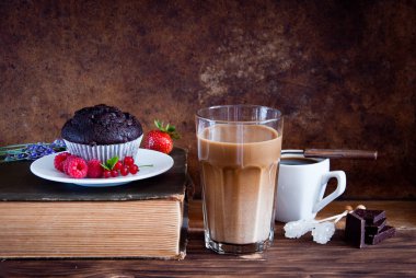 Kırmızı çilek ve kahve ve eski kitaplar ile Çikolatalı muffin