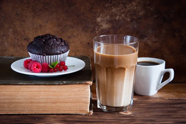 Kırmızı çilek ve kahve ve eski kitaplar ile Çikolatalı muffin